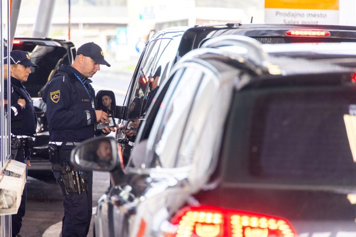 Police officers inspect documents at the border crossing in Obrezje